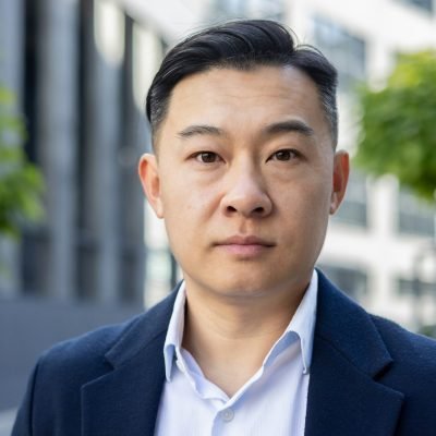 Confident asian businessman in suit posing for professional headshot outdoors